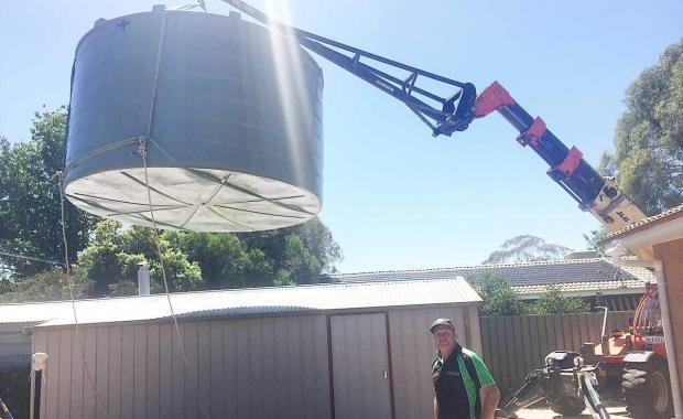 Lifting a 24000 litre rain water tank over a garage roof