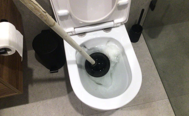 unblocking toilet paper using a using a plunger