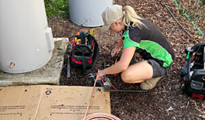apprentice plumber learning how to ben pipe for a new hot water system in Tuggeranong