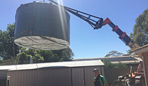 Lifting a 24000 litre rain water tank over a garage roof
